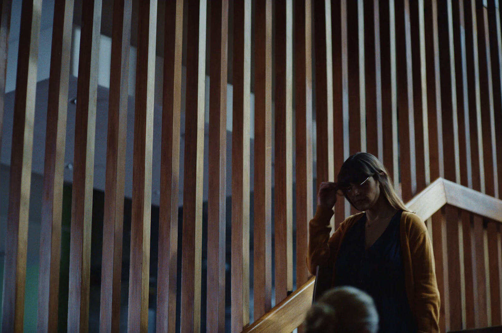 a woman is standing in front of a wooden wall