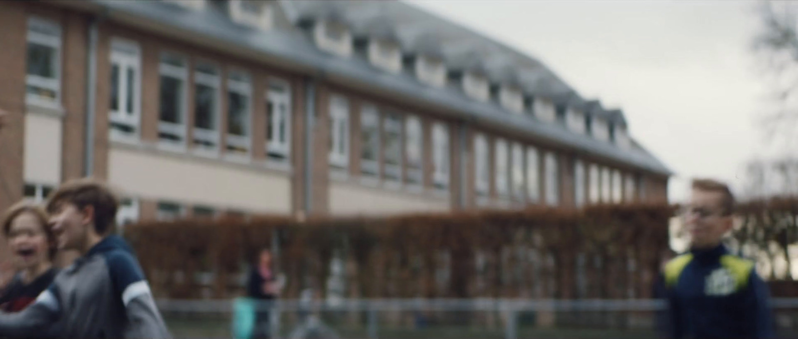 a blurry image of a group of children running in front of a building