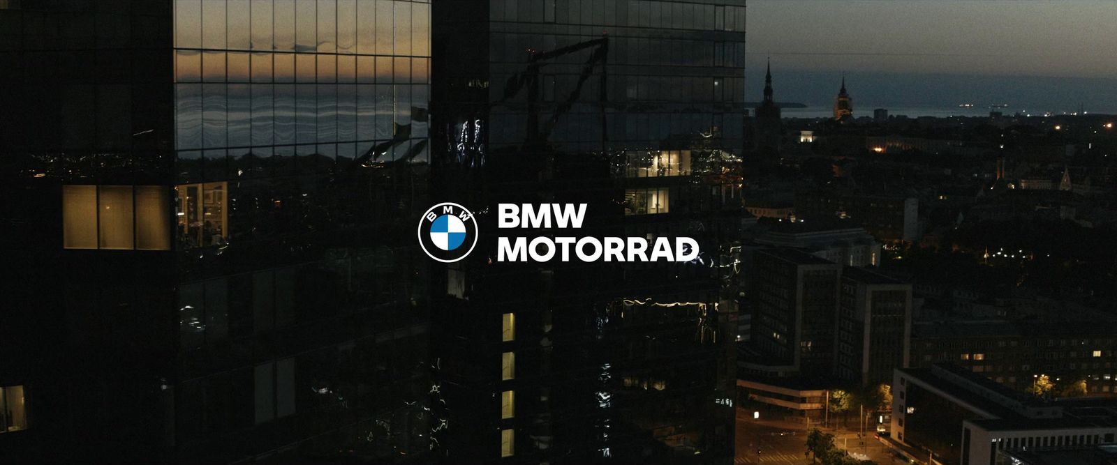 a view of a city at night with the bmw motorrad logo