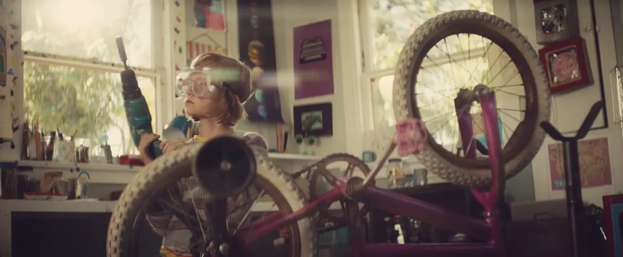 a young boy wearing goggles and holding a bike wheel