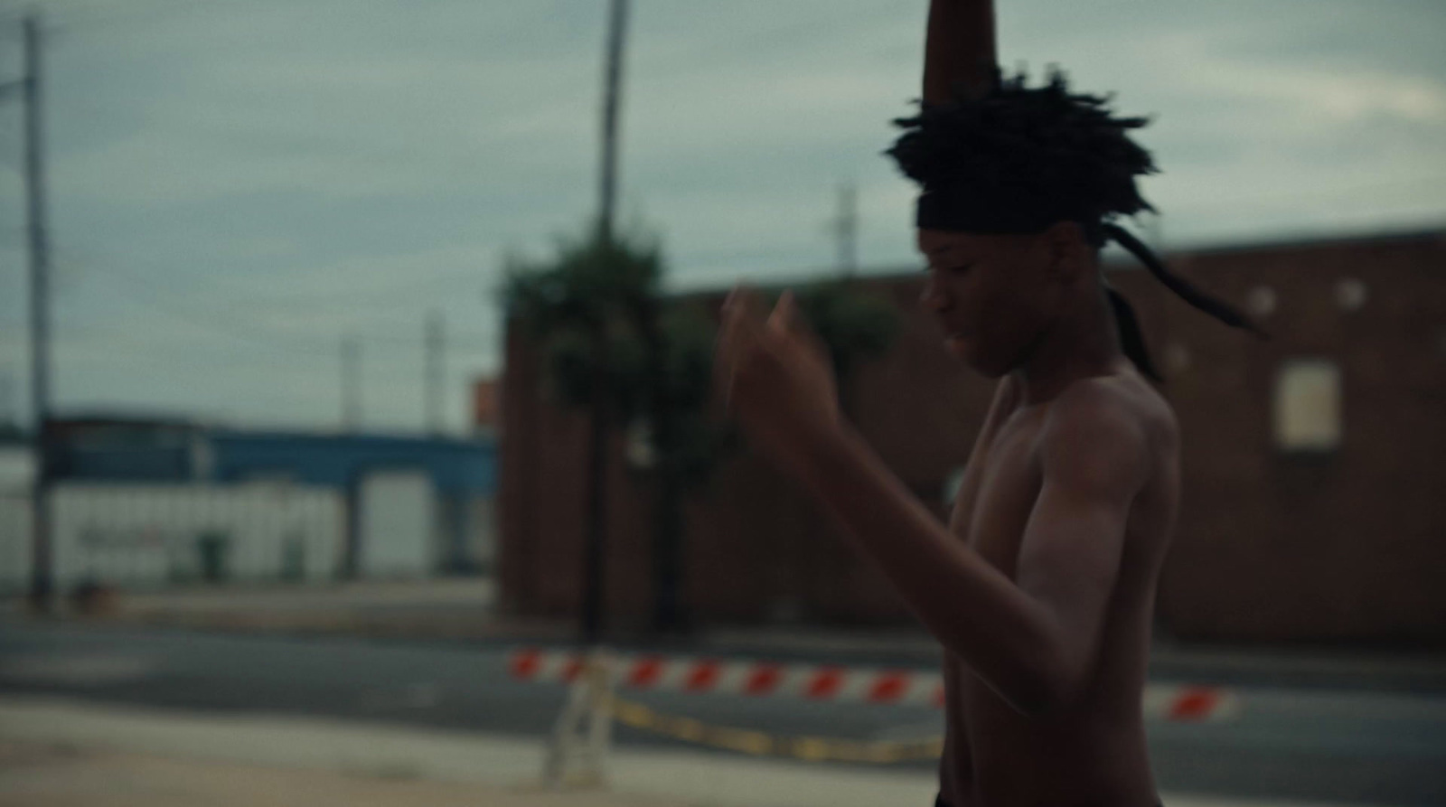 a man with dreadlocks on his head walking down the street