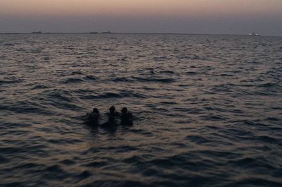 a group of people swimming in the ocean