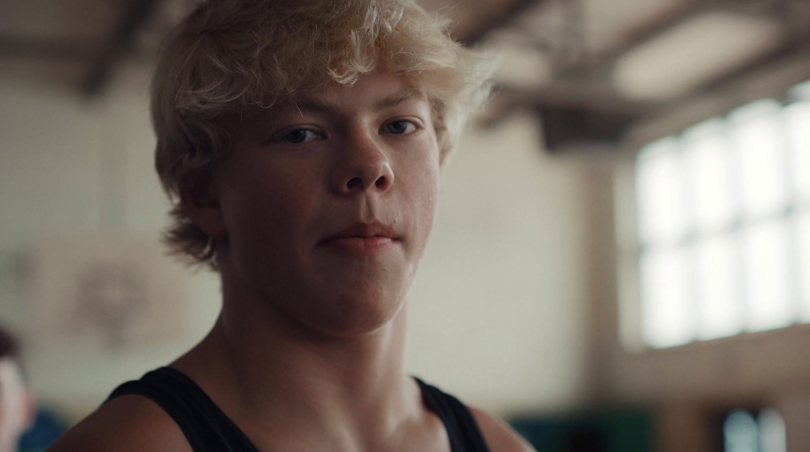 a man with blonde hair and a black tank top