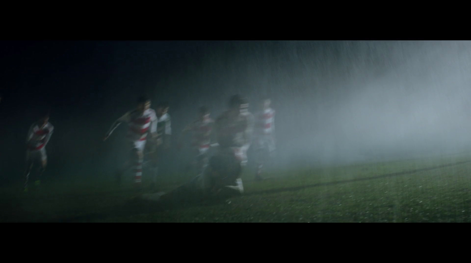 a group of soccer players playing in the rain