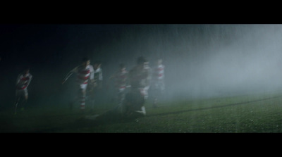 a group of soccer players playing in the rain