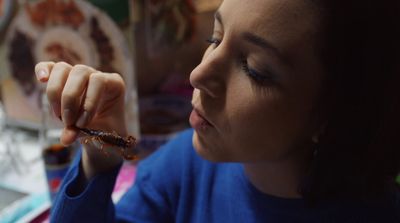 a woman holding a piece of food in her hand