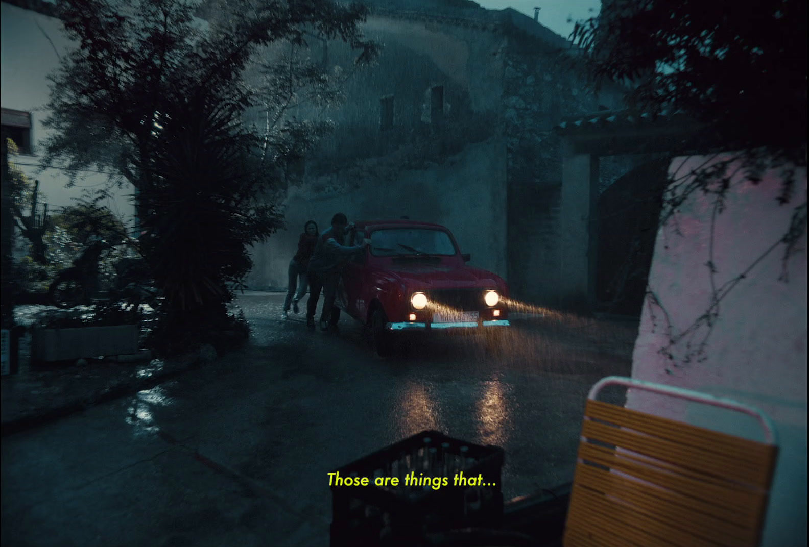 a man driving a car down a street in the rain