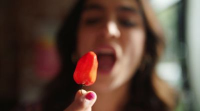 a woman holding a piece of food in her hand