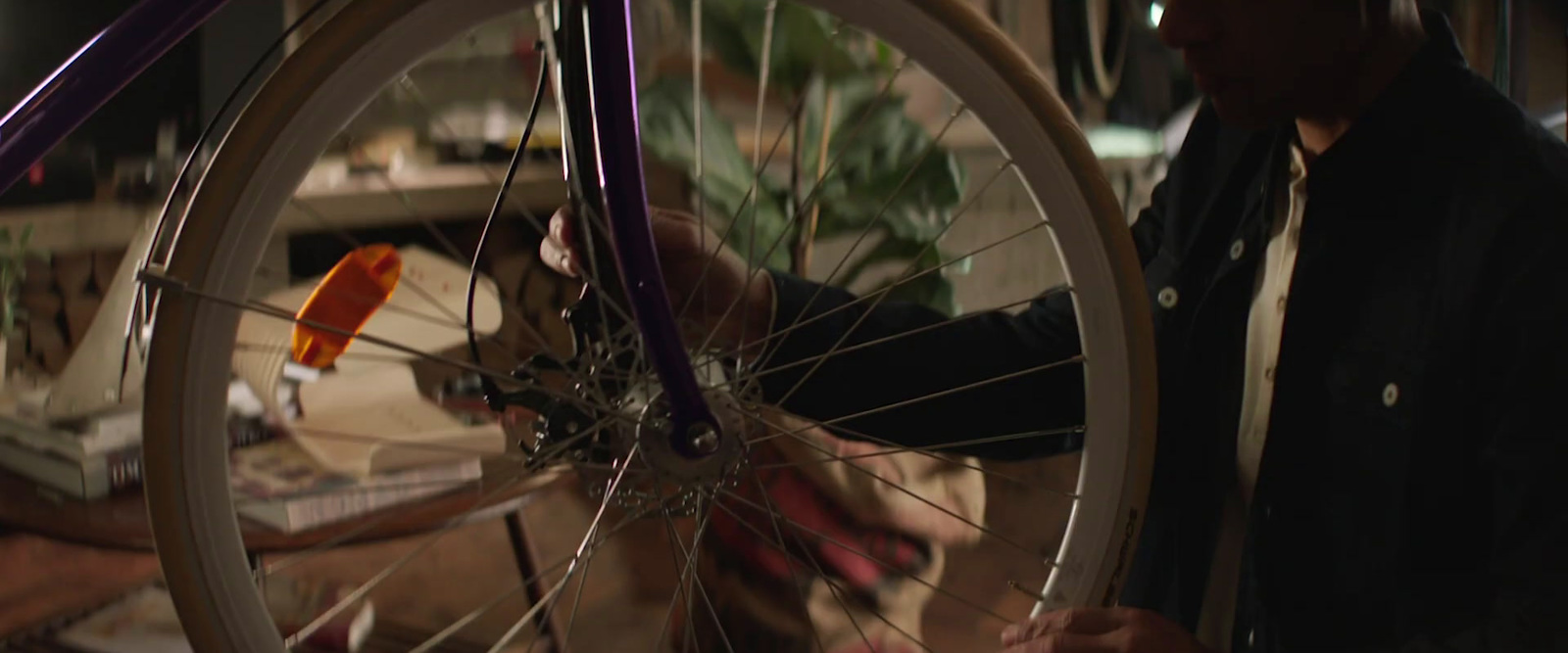 a man holding a bicycle wheel in his hand