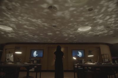 a woman is standing in a dimly lit room