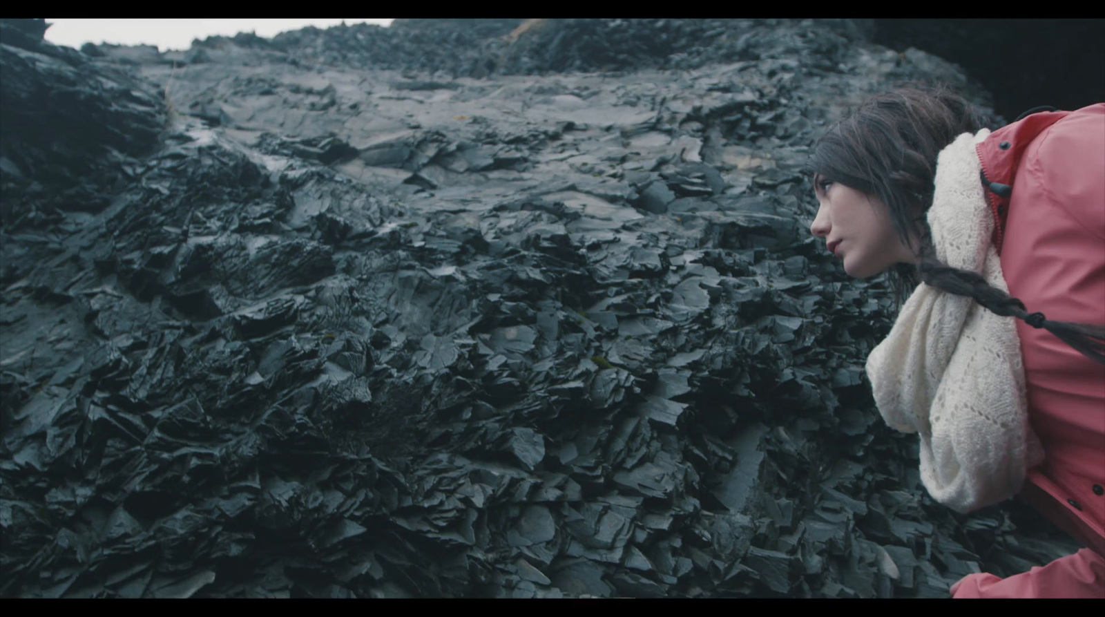 a woman in a red jacket walking through a pile of leaves