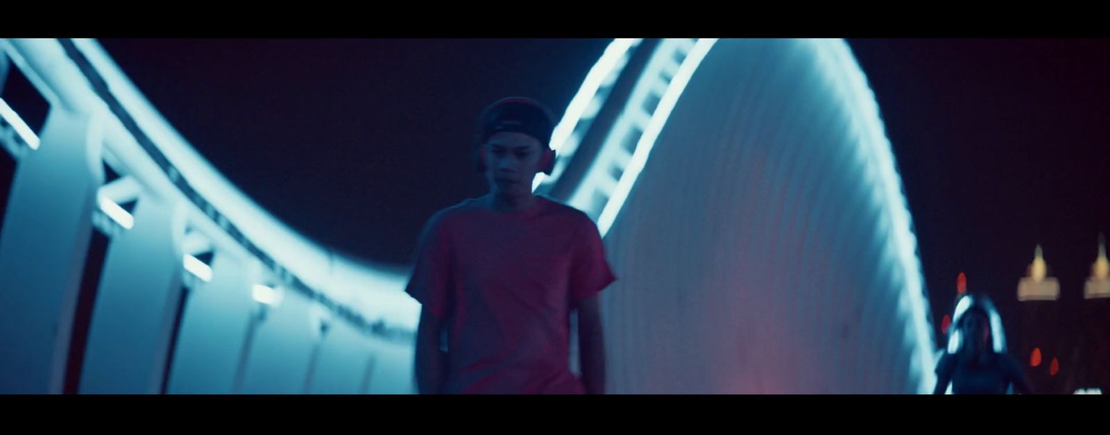 a man standing in front of a bridge at night