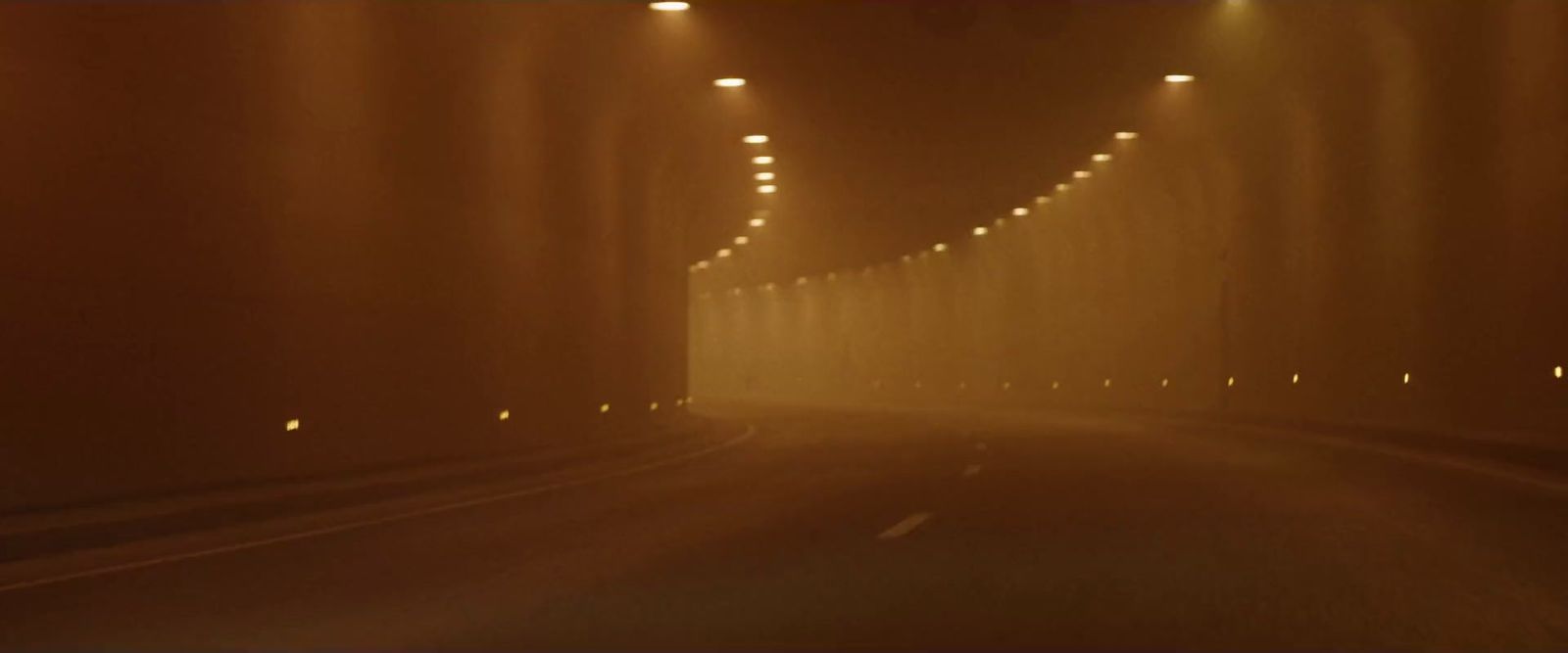 a car driving down a foggy road at night