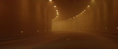 a car driving down a foggy road at night