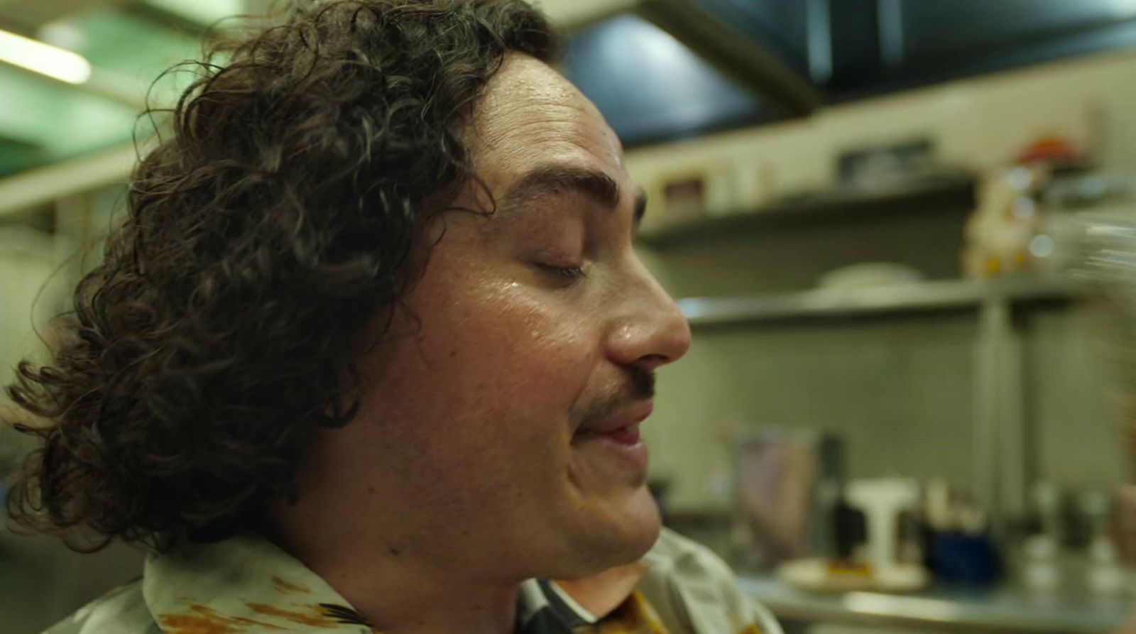 a man with curly hair wearing a tie