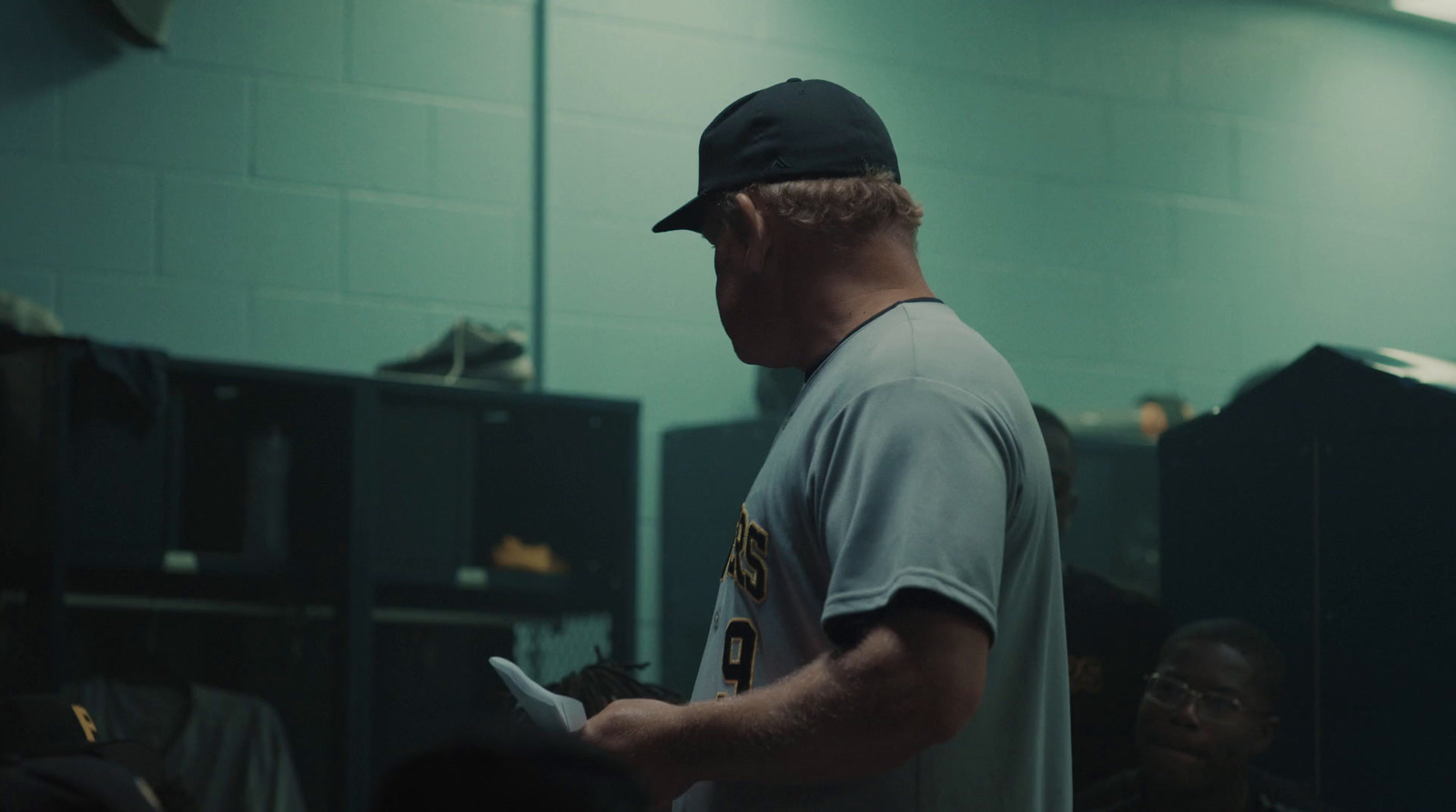 a man in a baseball uniform standing in a locker room