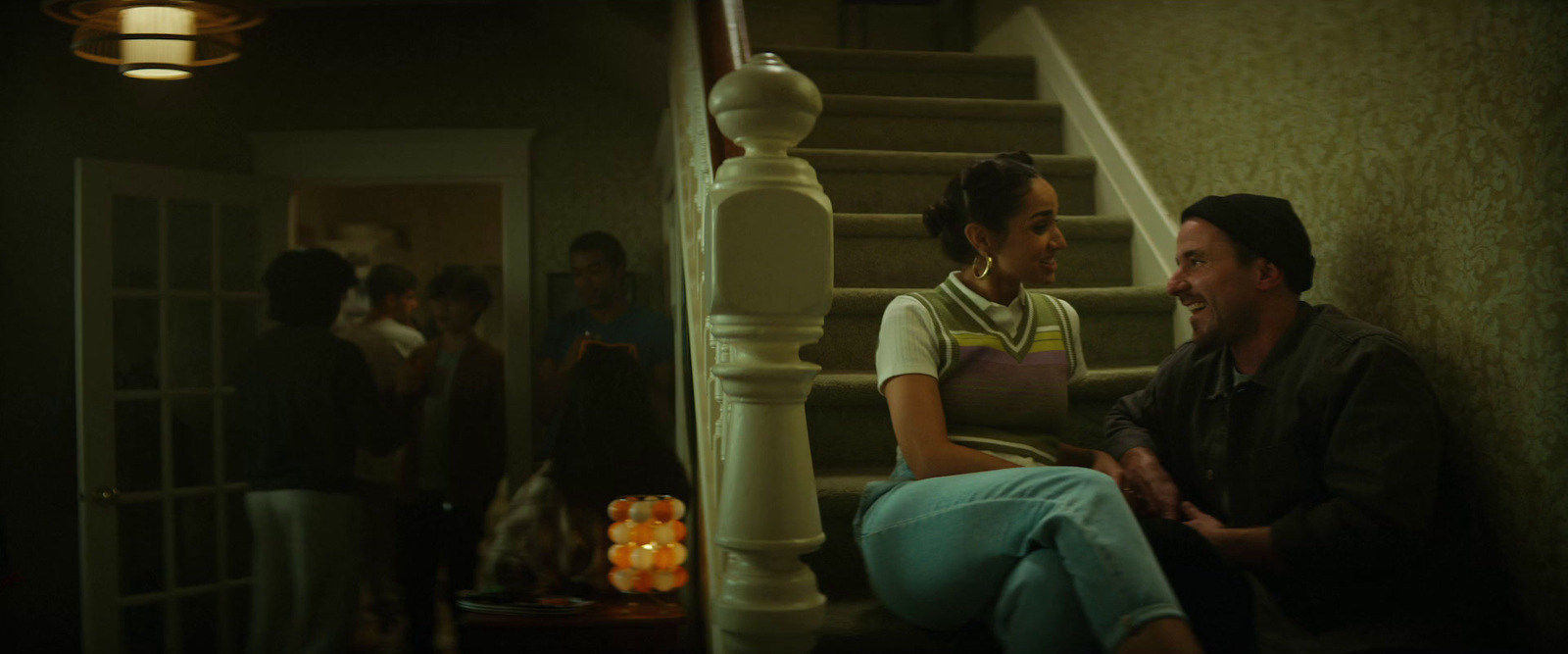 a man and woman sitting on the stairs in a house