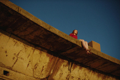 a woman sitting on the edge of a concrete wall