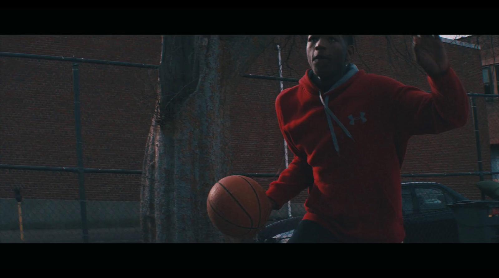 a man in a red jacket holding a basketball