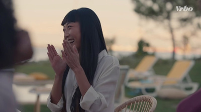 a woman sitting at a table clapping her hands