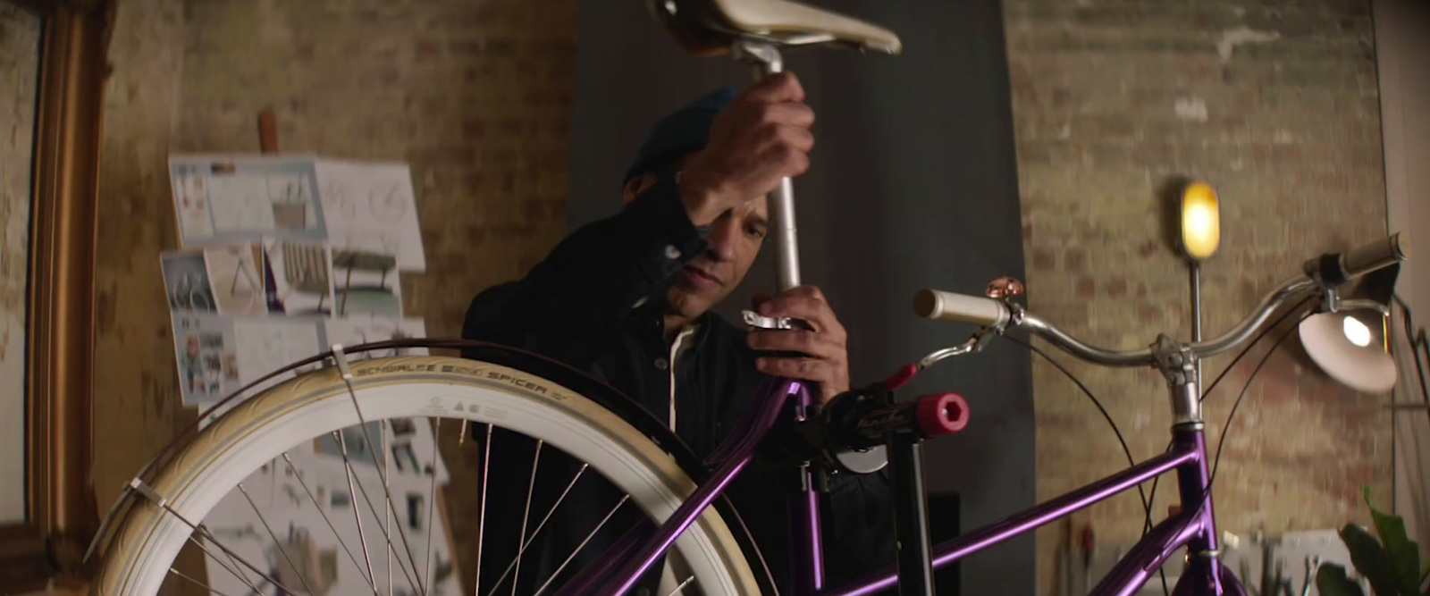 a man standing next to a purple bike