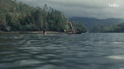 a man standing on a boat in the middle of a lake