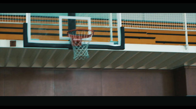 a basketball going through the hoop in a gym