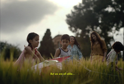 a group of children playing in a field with a kite