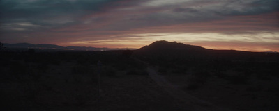 the sun is setting over a mountain range