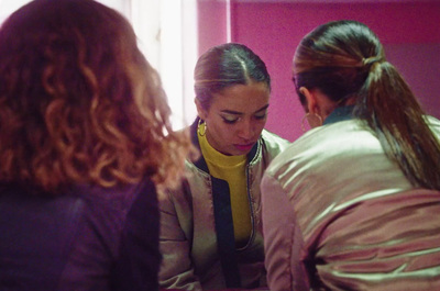 three women looking at their phones in a room