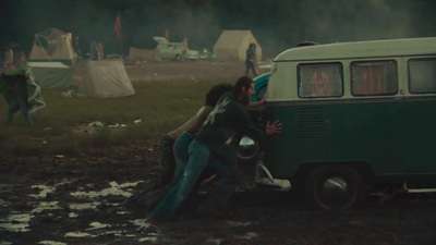 a group of people standing next to a green van