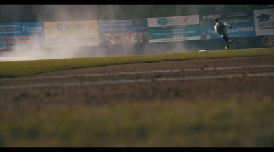 a person running on a dirt track near a field