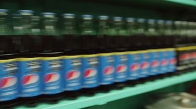 a row of soda bottles sitting on top of a shelf