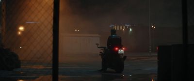 a man riding a motorcycle down a street at night