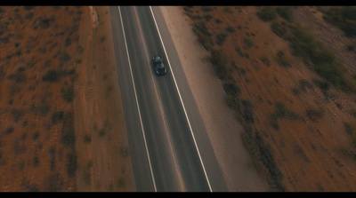 an aerial view of a car driving down a road