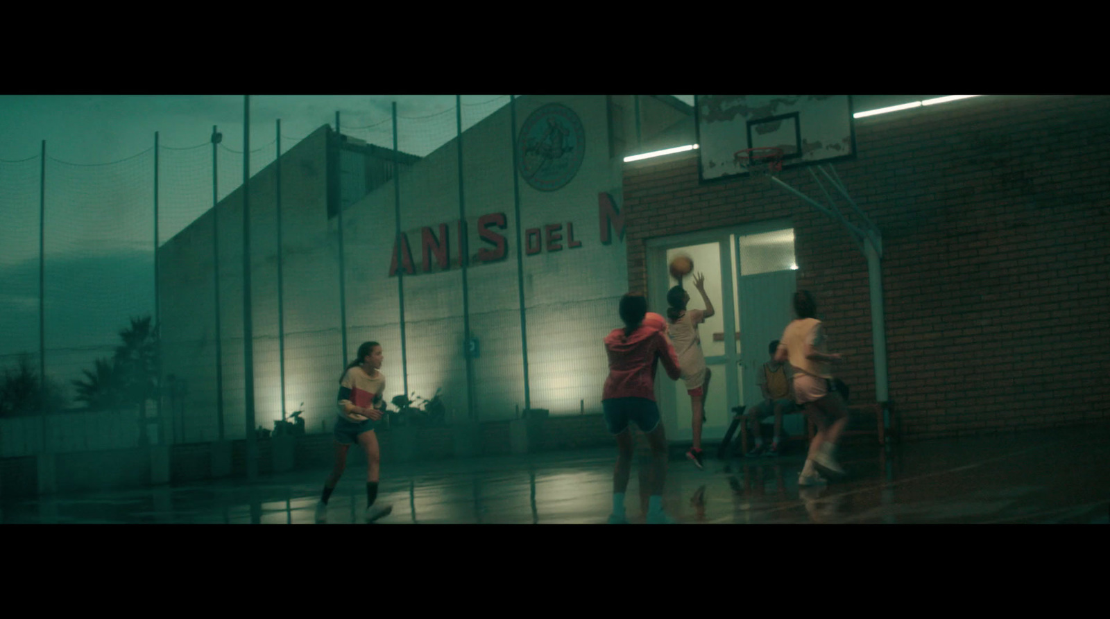 a group of people playing basketball in the rain