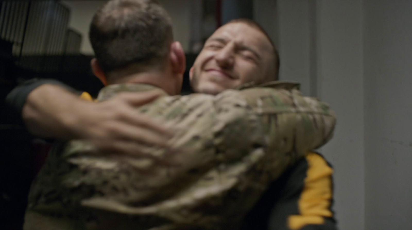 a couple of men hugging each other in a room