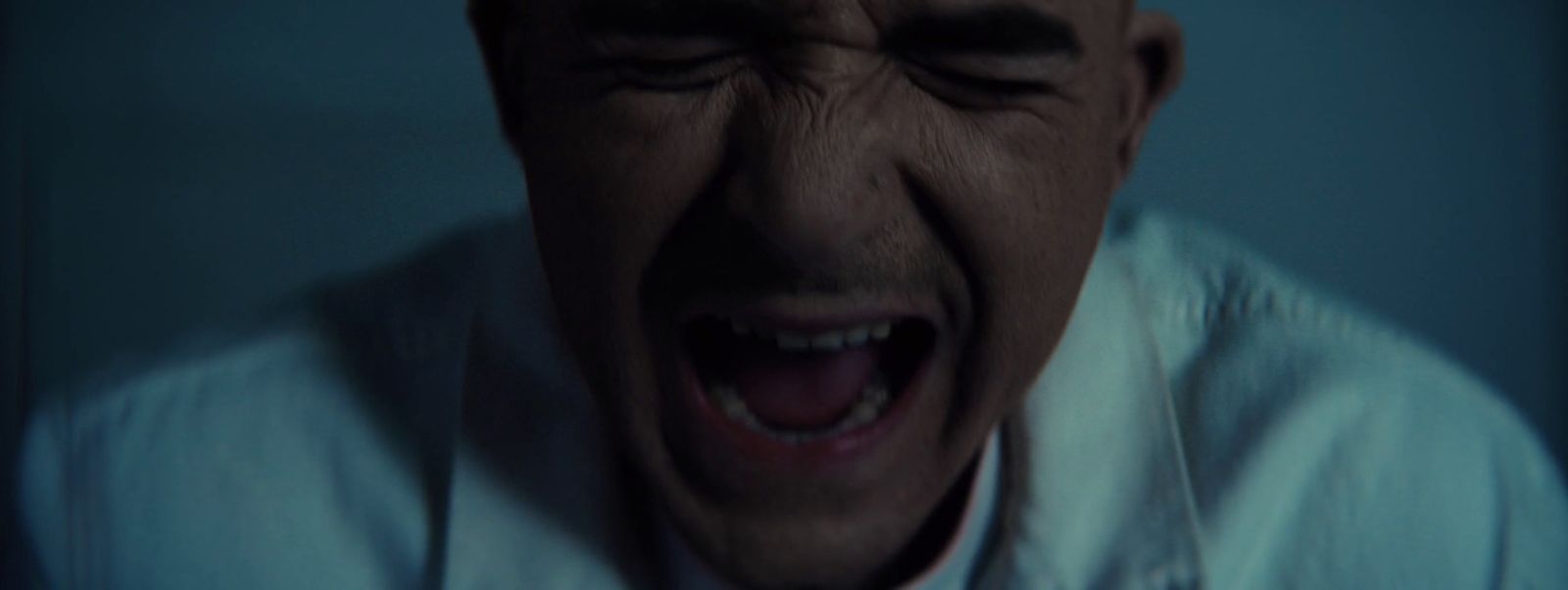 a man with his mouth open in a dark room