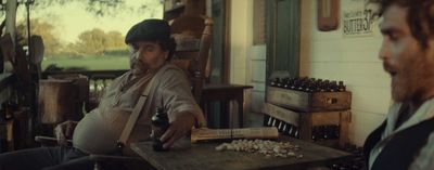 a man sitting at a table with a bottle of beer