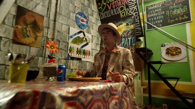 a man sitting at a table with a plate of food