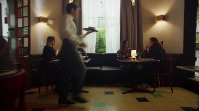 a man standing in front of a table in a restaurant