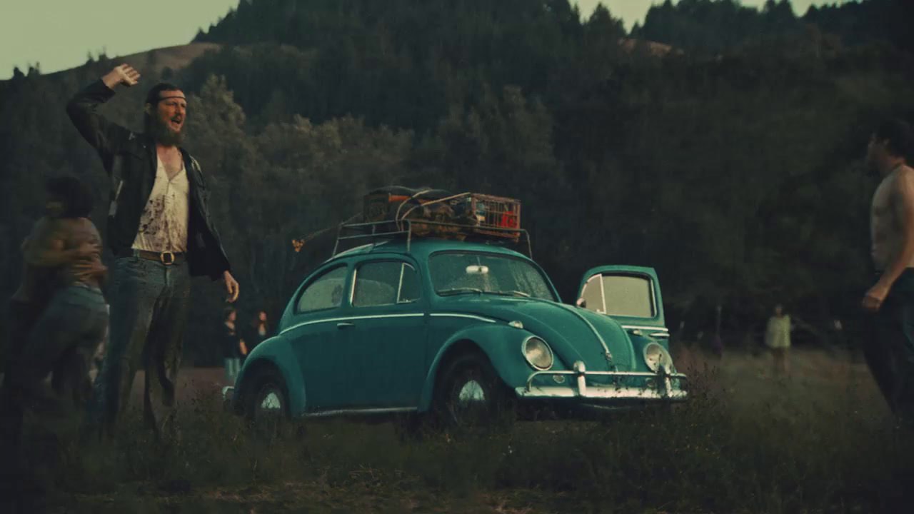 a group of people standing around a green car