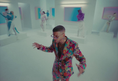 a man in a brightly colored suit is dancing