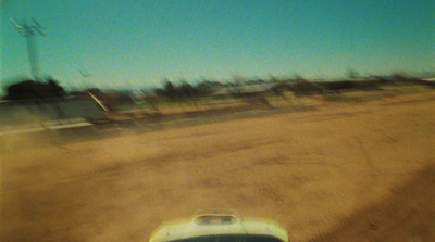 a blurry photo of a car parked on a dirt road