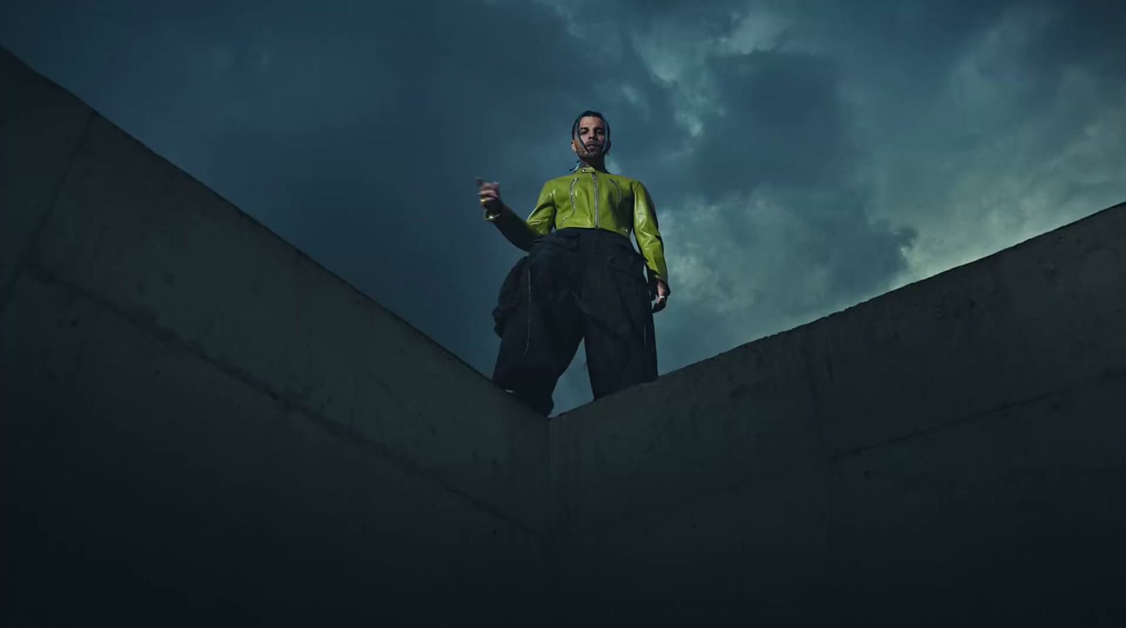 a man in a yellow shirt is standing on a ledge