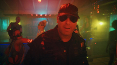 a man wearing sunglasses and a hat standing in a room