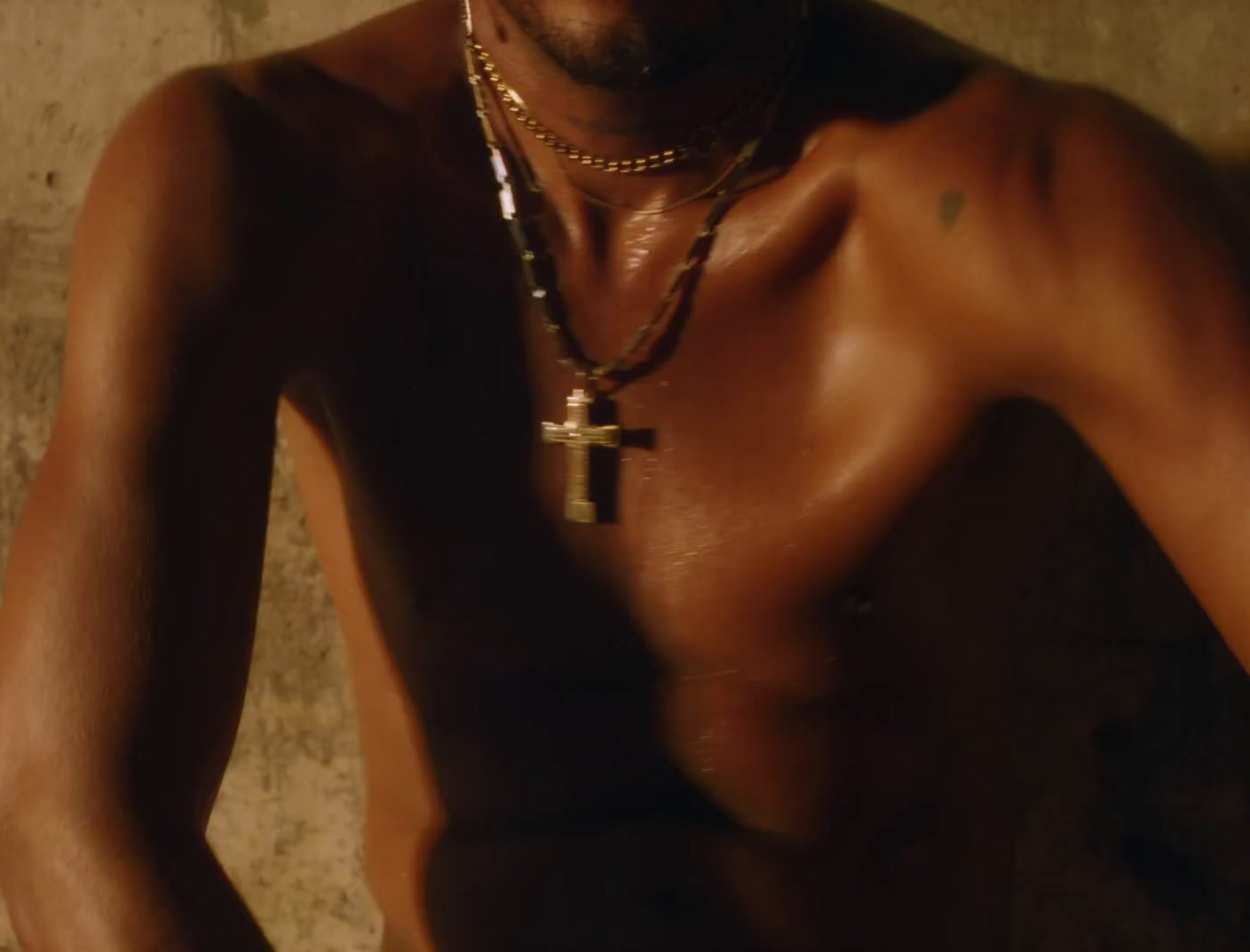 a shirtless man with a cross on his chest