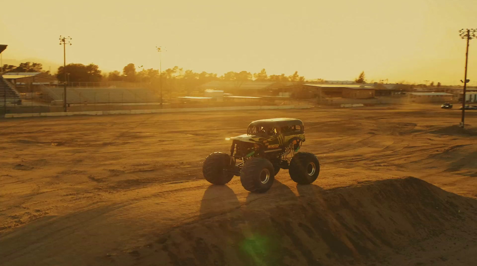 a monster truck driving down a dirt road