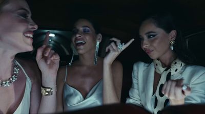 three women sitting in the back of a car