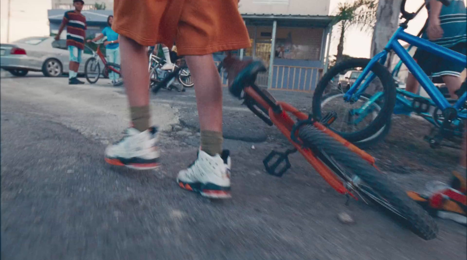 a man walking down a street next to a bike